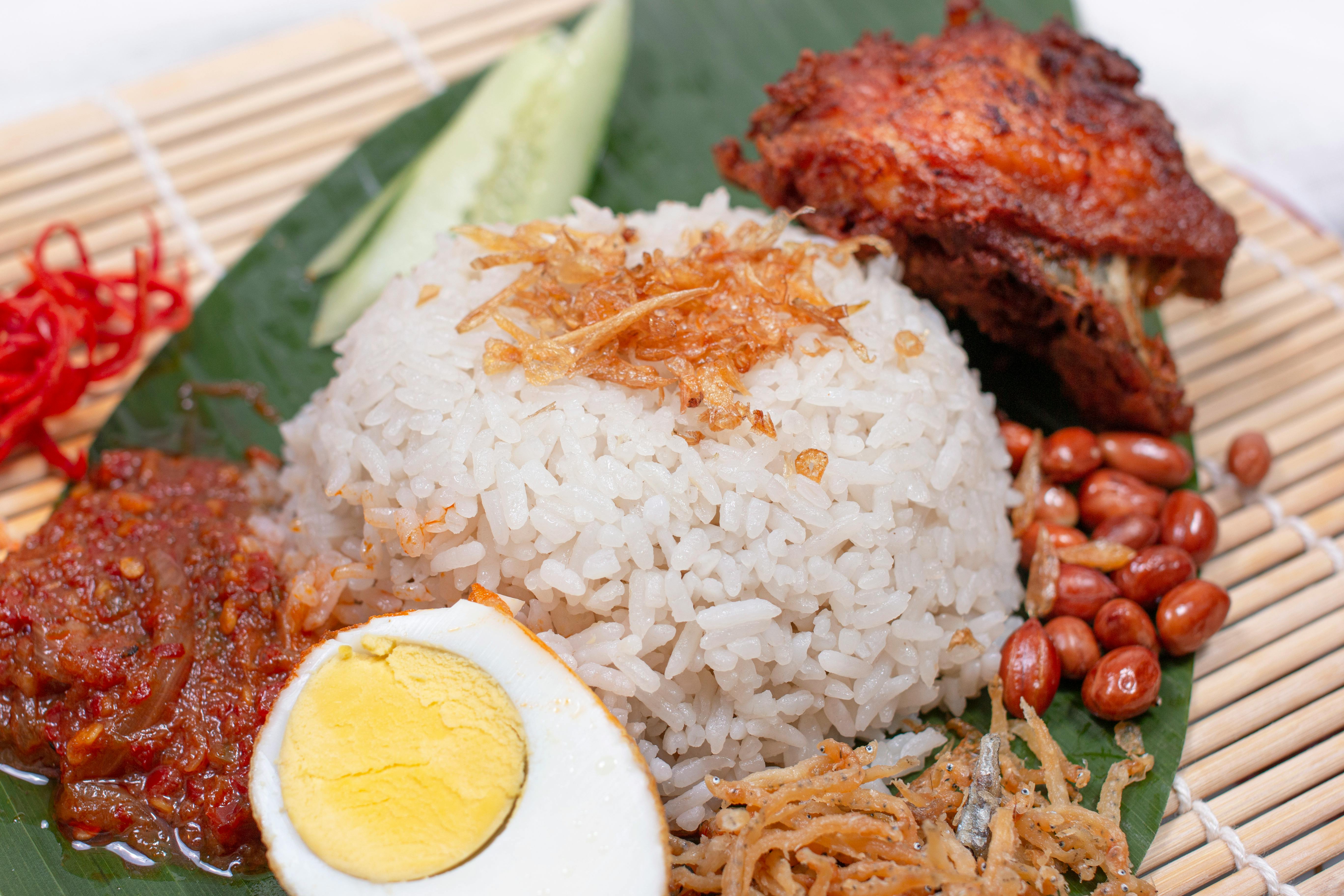 Delicious Nasi Lemak with chicken, sambal, and egg served on a banana leaf.